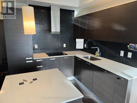 A modern kitchen with dark brown cabinets and a white countertop.