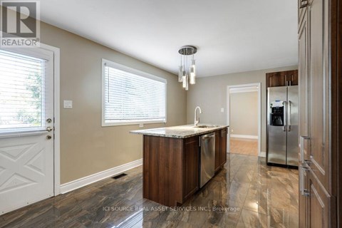 A kitchen with a wooden island and a refrigerator in the background.