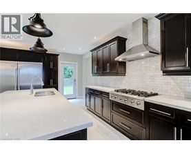 A modern kitchen with black cabinets and a white countertop.