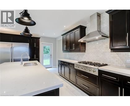 A modern kitchen with black cabinets and a white countertop.