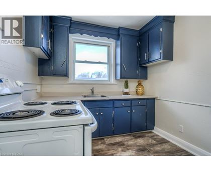 A kitchen with a white stove top oven and blue cabinets.