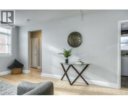 A living room with a grey sofa, a wooden coffee table, and a round mirror on the wall.