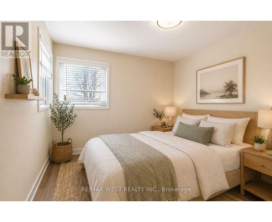 A bedroom with a bed, nightstand, and a plant.