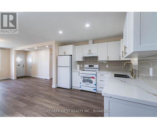 A kitchen with white cabinets and a white fridge.