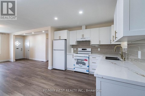 A kitchen with white cabinets and a white fridge.