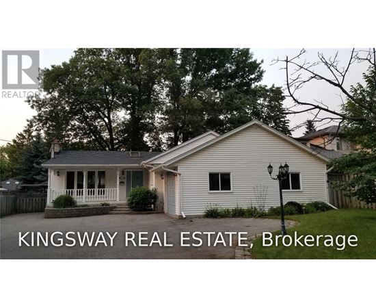A white house with a porch and a sign that says Kingsway Real Estate Brokerage.