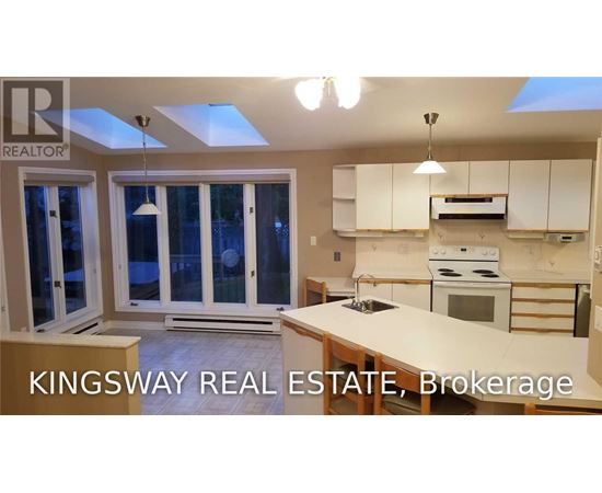 A kitchen with a skylight and a stove top oven.