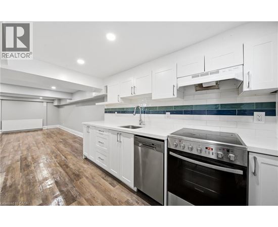 A modern kitchen with white cabinets and stainless steel appliances.
