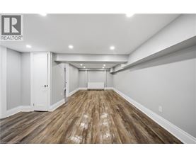 A spacious room with wooden flooring and white walls.