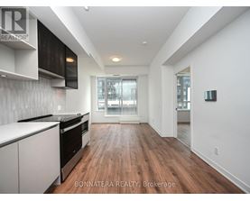 A modern kitchen with white cabinets and black appliances.
