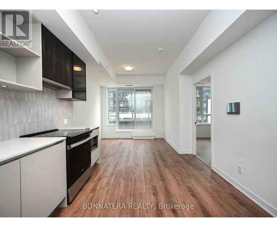 A modern kitchen with white cabinets and black appliances.