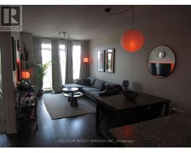 A living room with a couch, a coffee table, and a mirror.