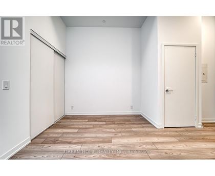 A room with a wooden floor and a white door.