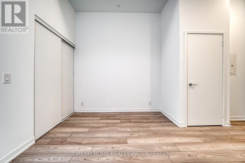 A room with a wooden floor and a white door.