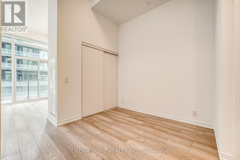 A room with wooden flooring and a sliding door.