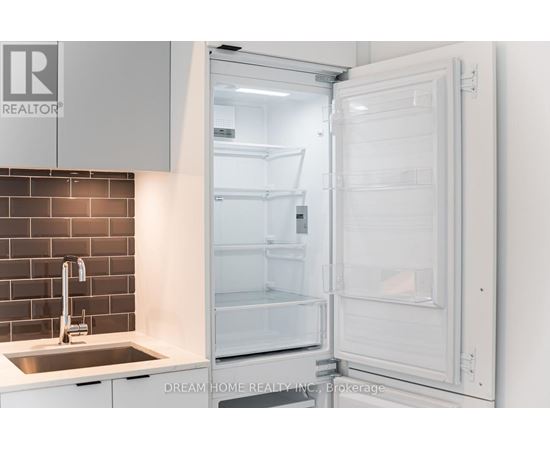 A white refrigerator is open in a kitchen.