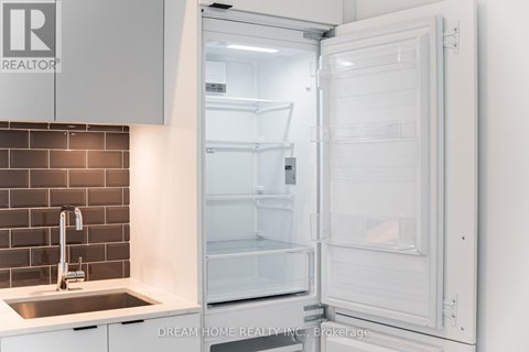 A white refrigerator is open in a kitchen.