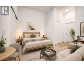 A bedroom with a bed, a chair, a table, and a couch.