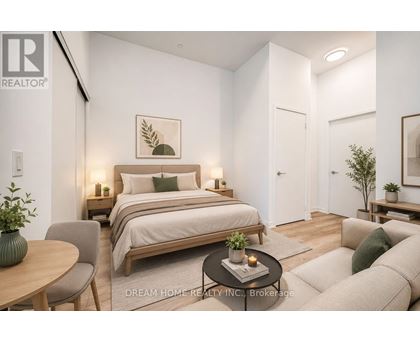A bedroom with a bed, a chair, a table, and a couch.