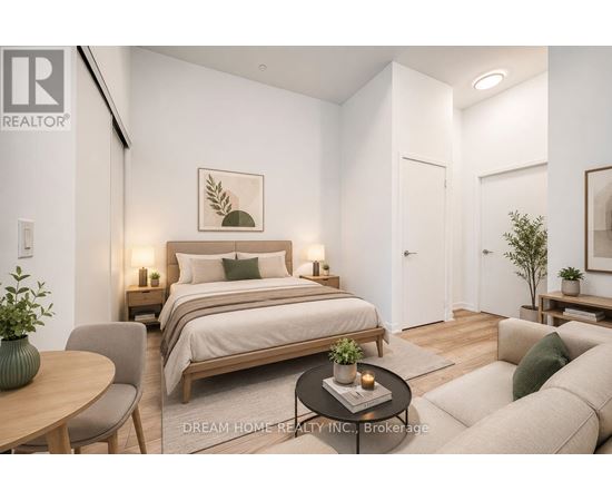 A bedroom with a bed, a chair, a table, and a couch.