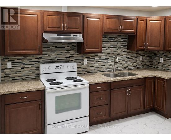 A kitchen with a white stove top oven and brown cabinets.