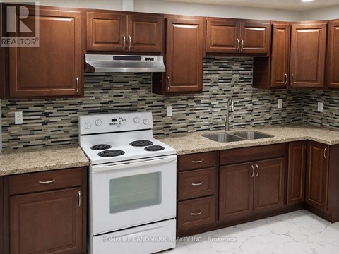 A kitchen with a white stove top oven and brown cabinets.