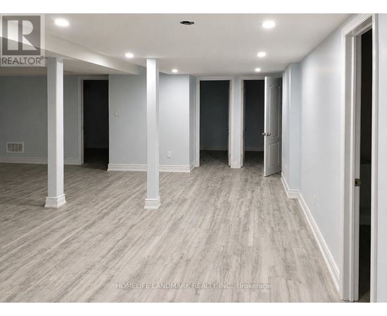 A long hallway with white walls and wood flooring.