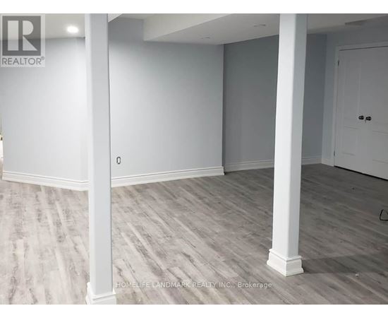 A room with white pillars and grey carpet.