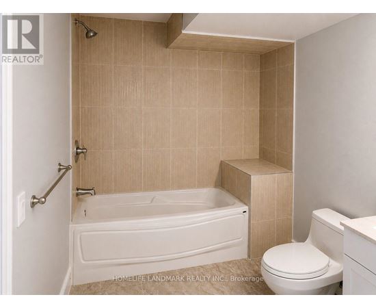A bathroom with a white tub and tiled walls.