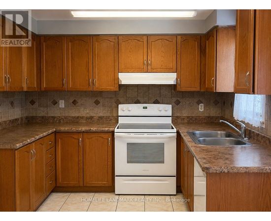 A kitchen with wooden cabinets and a white stove top oven.