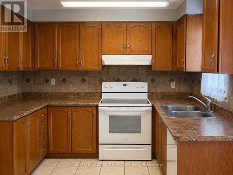 A kitchen with wooden cabinets and a white stove top oven.