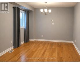 A room with wooden flooring and a chandelier.