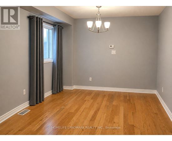 A room with wooden flooring and a chandelier.
