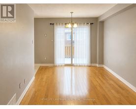 A room with wooden flooring and a sliding glass door.