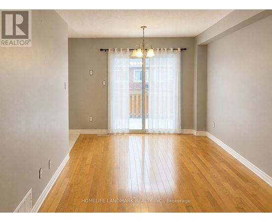 A room with wooden flooring and a sliding glass door.