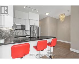 A modern kitchen with white cabinets and a black countertop.