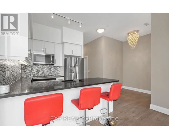 A modern kitchen with white cabinets and a black countertop.