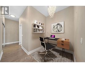 A room with a desk, chair, and a painting on the wall.