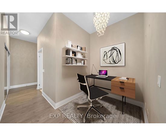 A room with a desk, chair, and a painting on the wall.