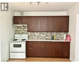 A kitchen with white appliances and brown cabinets.