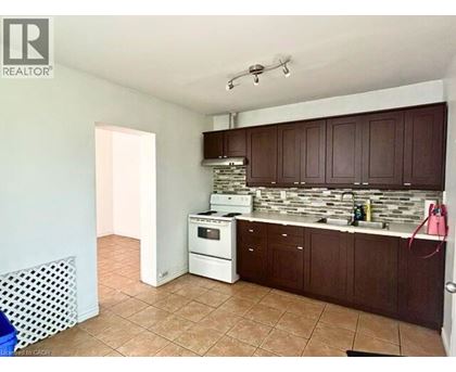 A kitchen with brown cabinets and a white dishwasher.