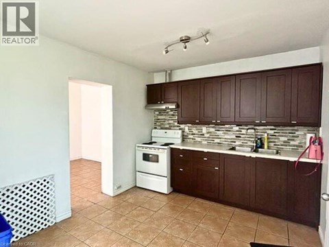 A kitchen with brown cabinets and a white dishwasher.
