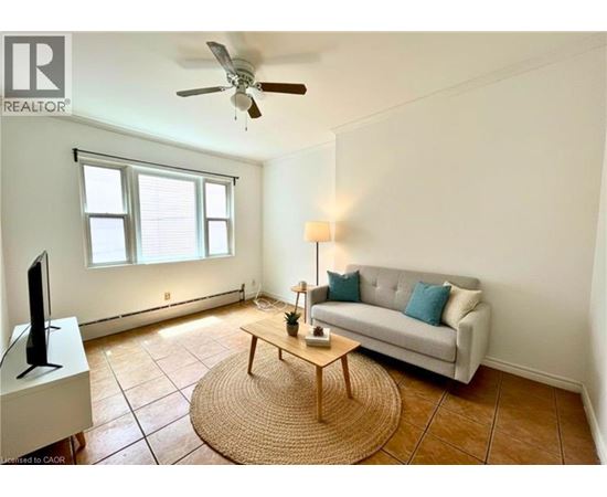 A living room with a couch, a coffee table, and a television.