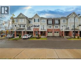 A large apartment complex with multiple buildings and cars parked in the driveway.