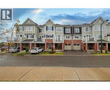 A large apartment complex with multiple buildings and cars parked in the driveway.