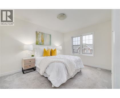 A bedroom with a large bed and a painting on the wall.