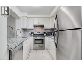 A modern kitchen with white cabinets and stainless steel appliances.