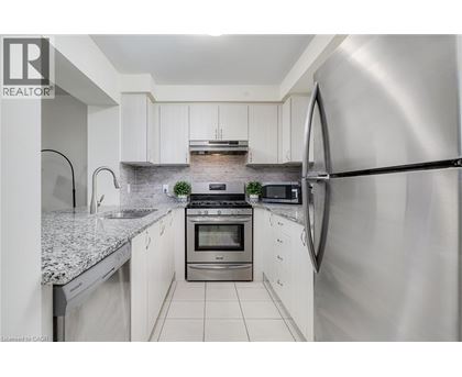 A modern kitchen with white cabinets and stainless steel appliances.