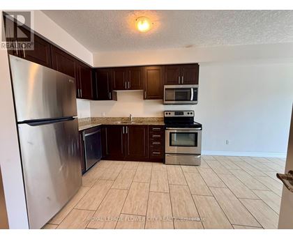 A kitchen with a refrigerator, microwave, oven and cabinets.