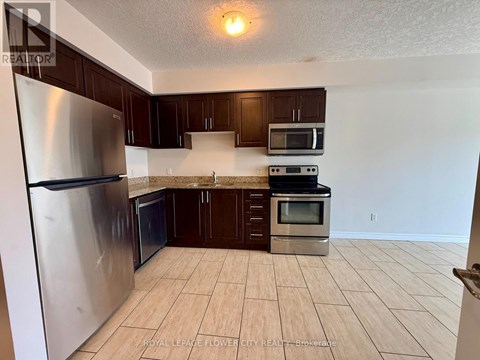 A kitchen with a refrigerator, microwave, oven and cabinets.